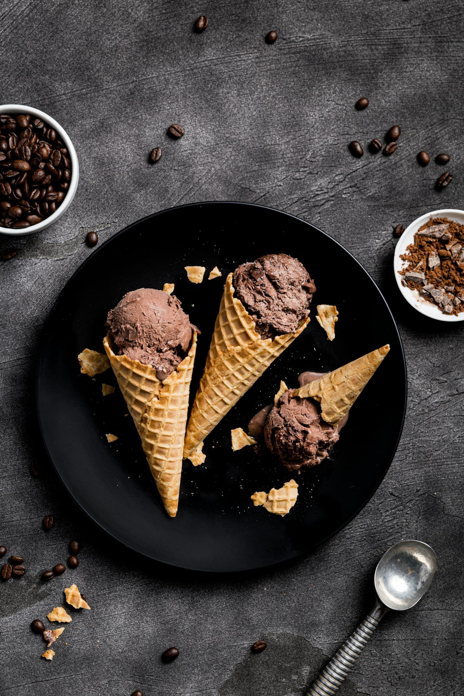 Chocolate ice cream in waffle cones on a dark plate