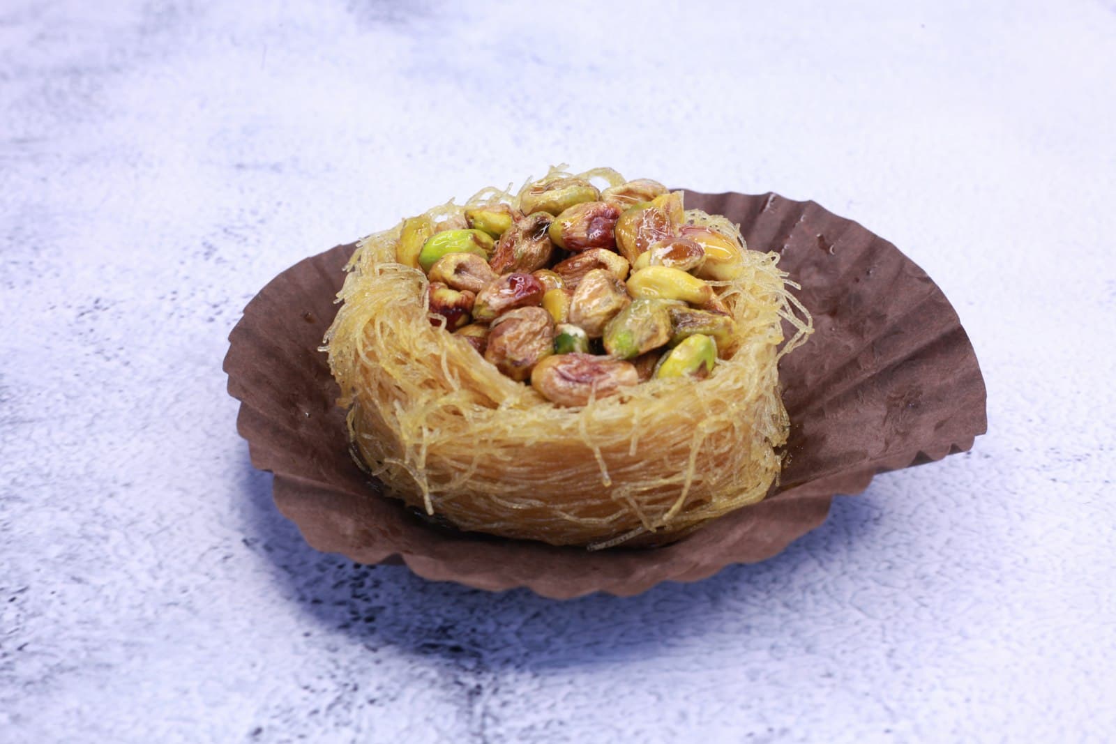 A crisp kataifi pastry nest filled with chopped pistachios